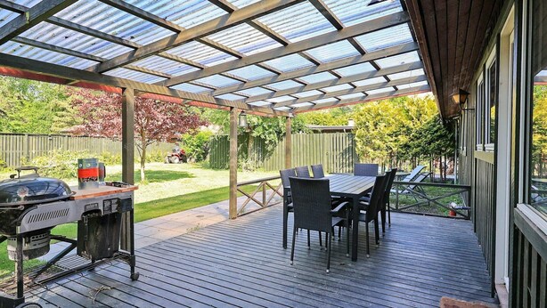 A covered patio with a grill, dining table, and chairs. - 10 Person Holiday Home in Dragor (Dragor)