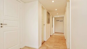 A hallway with white doors and wooden flooring. - 10 Person Holiday Home in Dragor (Dragor)