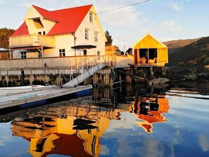 A waterfront property with a house and a small cabin, connected by a dock.