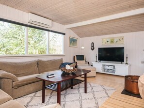 Una sala de estar con sofá, mesa de centro, televisor y chimenea.