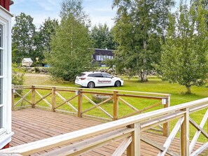 A white car parked on a wooden deck with a view of a house and trees in the background. - 4 Star Holiday Home in Hjo (Hjo)