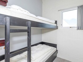 Habitación con literas, una ventana y una puerta.