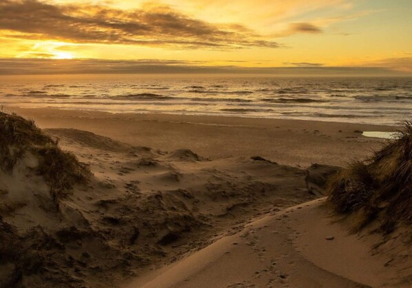 A beach with sand dunes and a sunset. - 6 Person Holiday Home in Ringkobing (Ringkobing)
