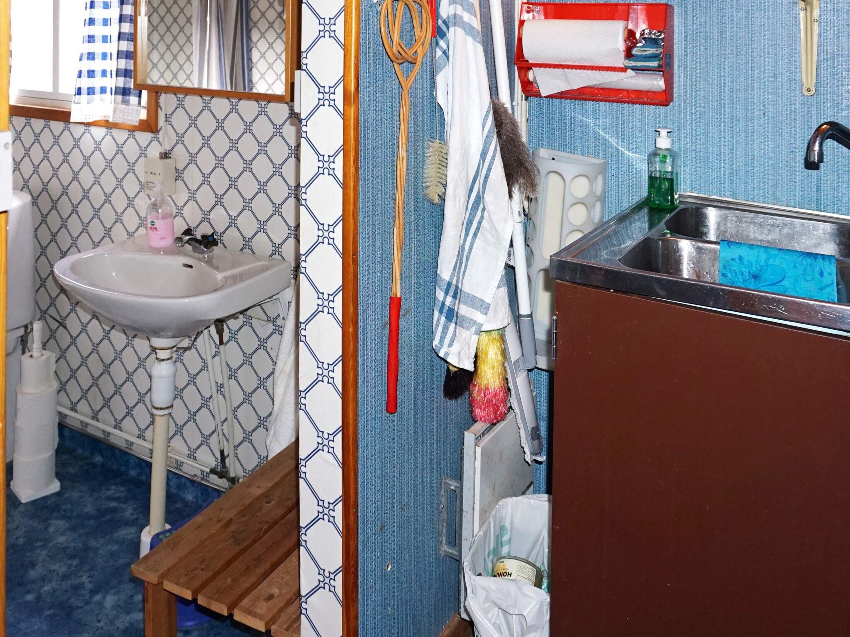 A bathroom with a sink, a mirror, a towel rack, and a toilet.