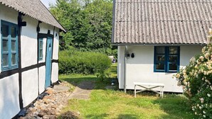 A traditional cottage with a stone pathway leading to a wooden bench. - 5 Person Holiday Home in Bogo By (Bogø By)