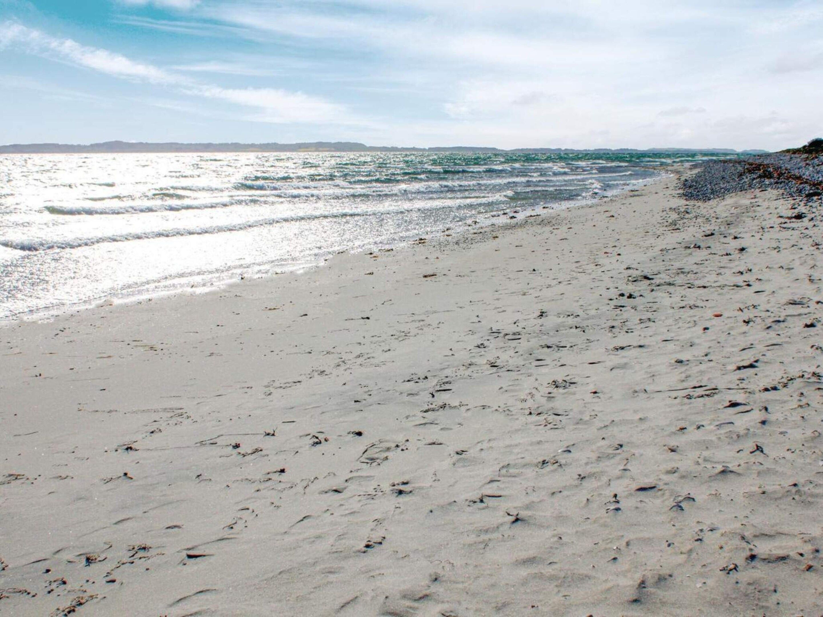 A beach with a sandy shore and waves.