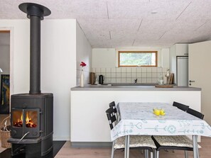 A modern kitchen with a central island, a built-in stove, and a dining area with a table set for two. - 4 Person Holiday Home in Ebeltoft (Ebeltoft)