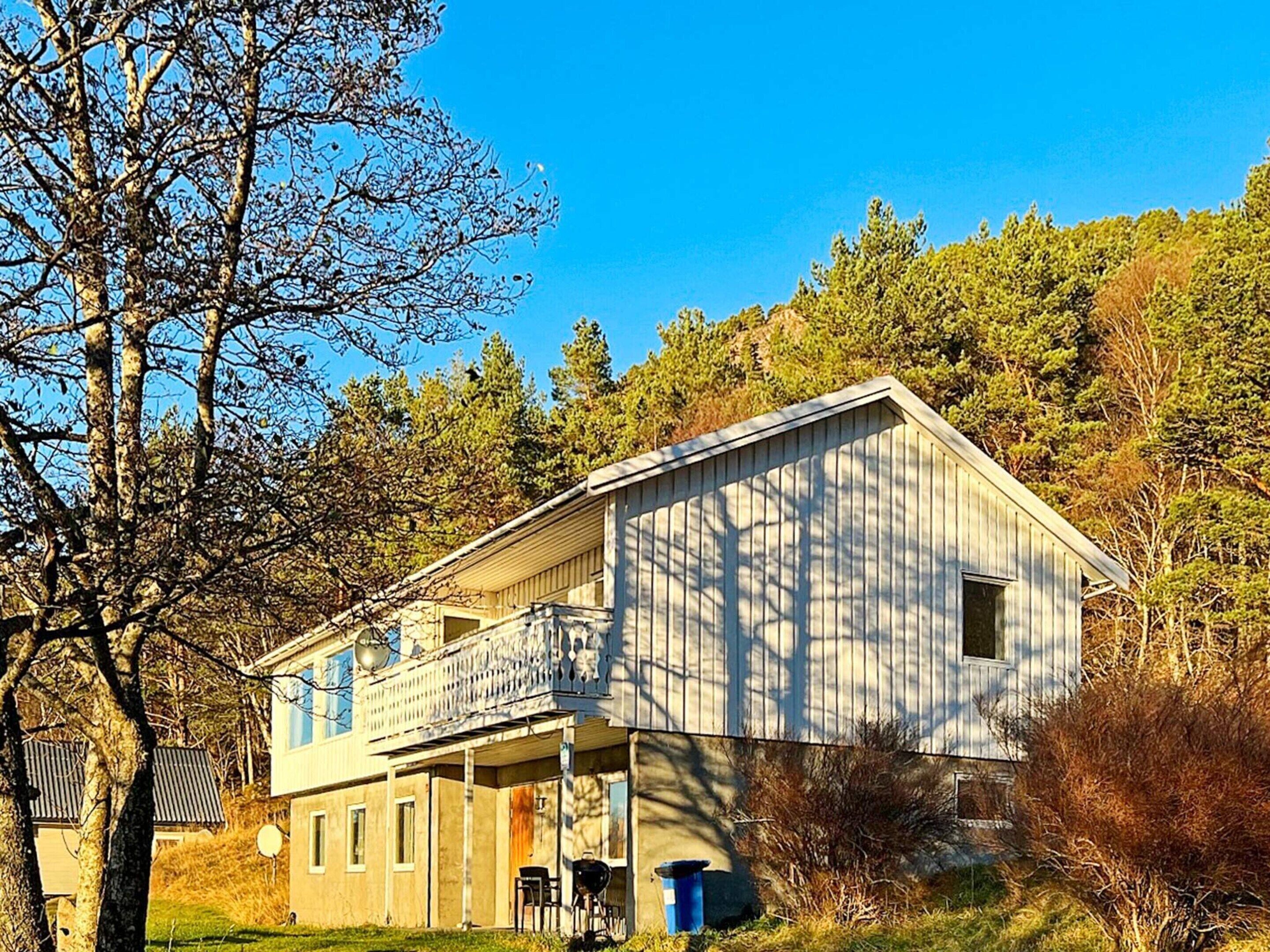 A two-story house with a balcony, a garage, and a small porch area.