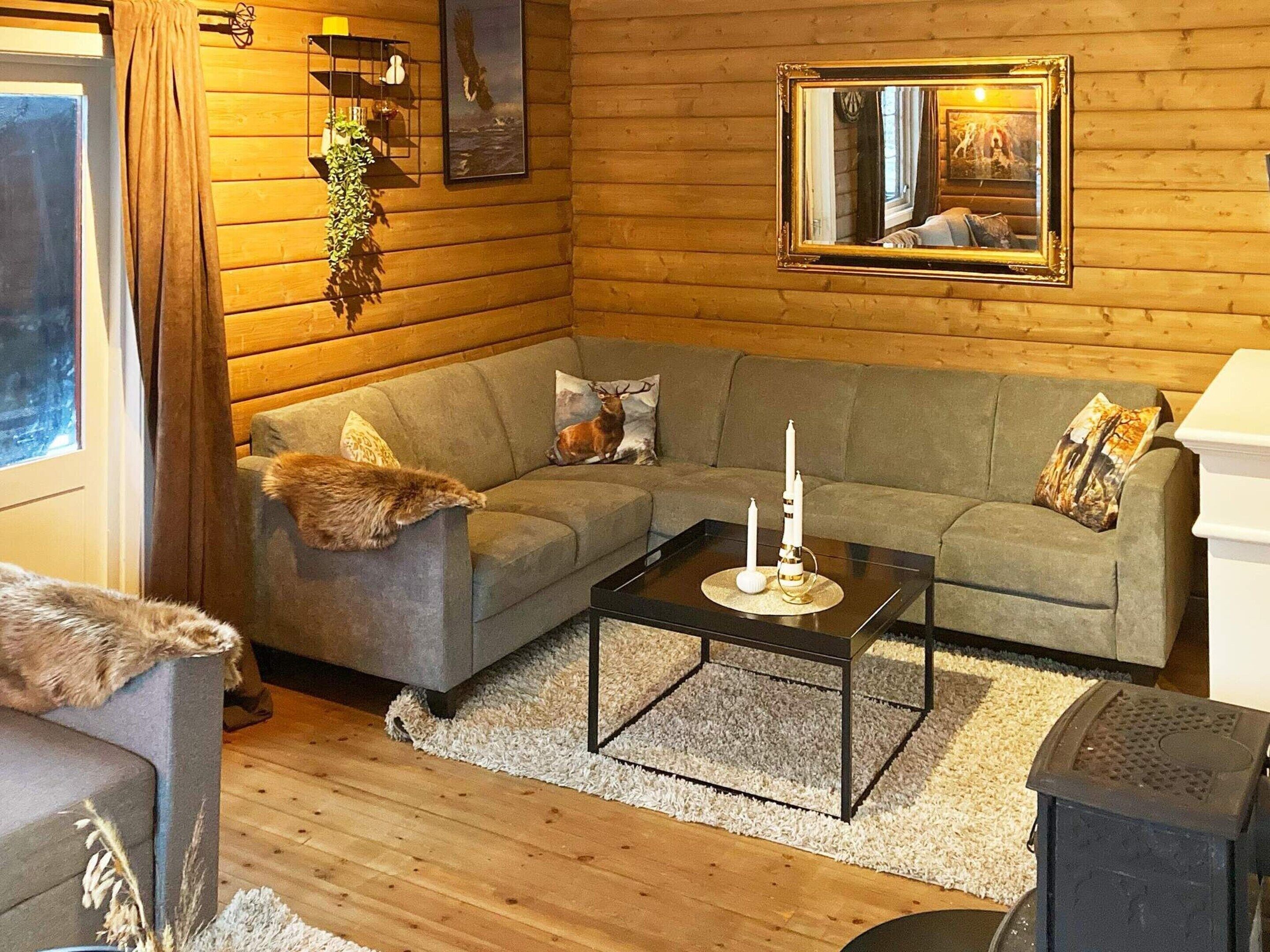 A cozy living room with a grey sofa, a small coffee table, and a fireplace.