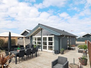 A patio area with outdoor furniture, a covered seating area, and potted plants. - 4 Star Holiday Home in Otterup (Otterup)