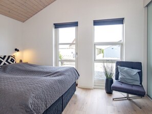 A bedroom with a bed, a chair, a window, and a plant. - 4 Star Holiday Home in Otterup (Otterup)
