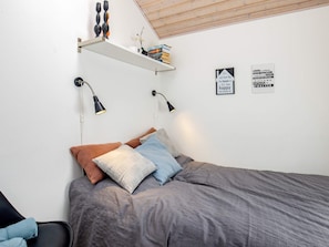 A bedroom with a bed, two wall-mounted lamps, a shelf with books and decorative items, and two motivational wall signs. - 4 Star Holiday Home in Otterup (Otterup)