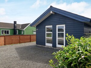 A residential building with a dark blue exterior, a white door, and a window.