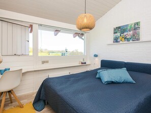 A bedroom with a large bed, a window with a view of the outdoors, a desk, and a chair. - 4 Person Holiday Home in Aabenraa (Aabenraa)