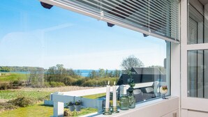 Ein Balkon mit Seeblick, einem weißen Geländer und einem Fenster mit einer verzierten Eule.