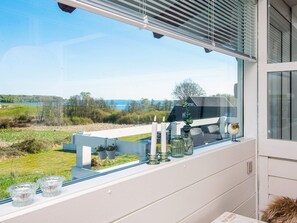 A balcony with a view of a lake, a white railing, and a window with a decorative owl. - 4 Person Holiday Home in Aabenraa (Aabenraa)