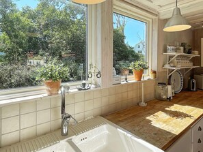 A kitchen with a large window, a sink, and a wooden countertop. - 4 Star Holiday Home in Ellos (Ellos)