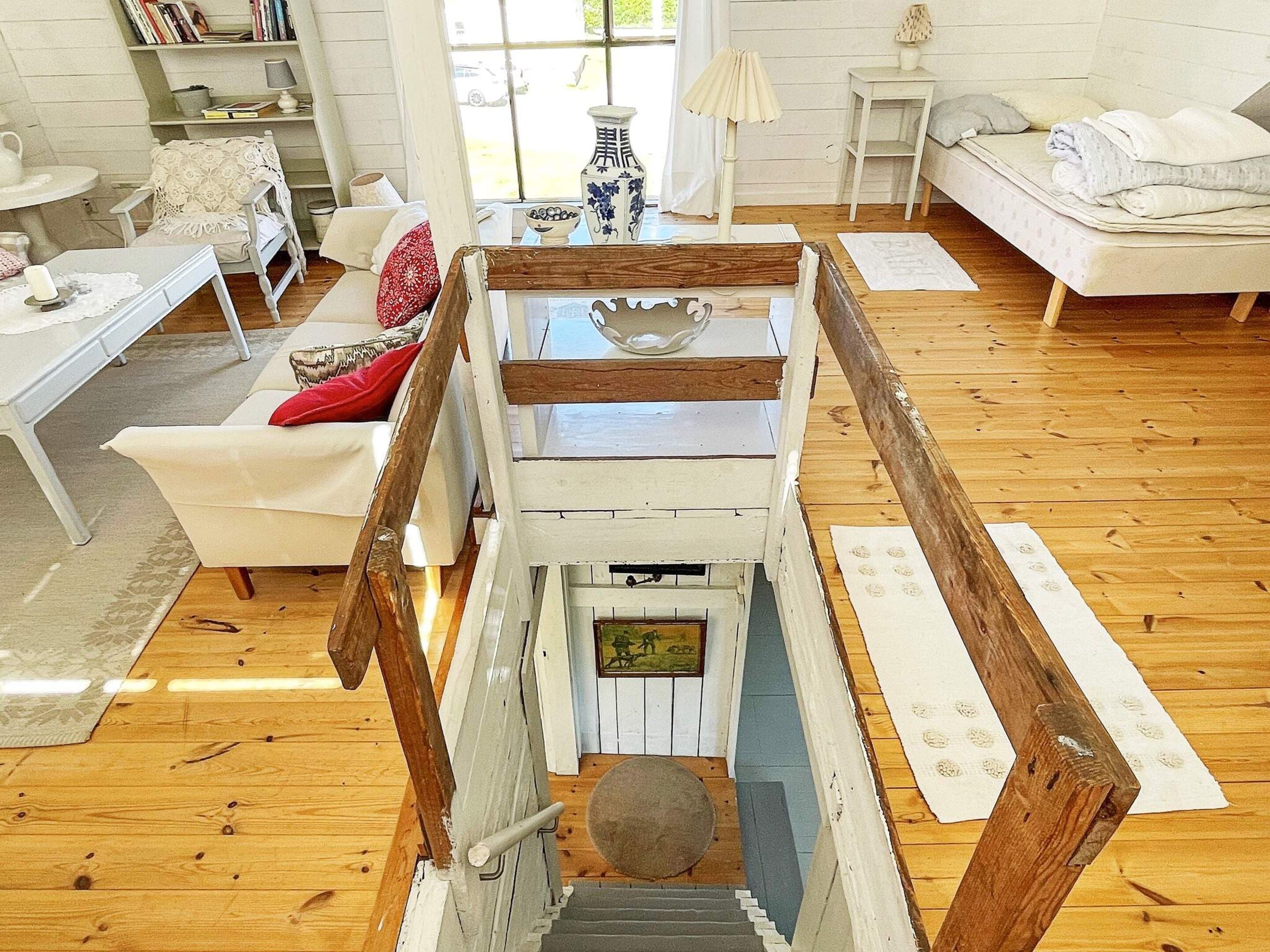 A wooden staircase leading to a loft area with a view of the outdoors.