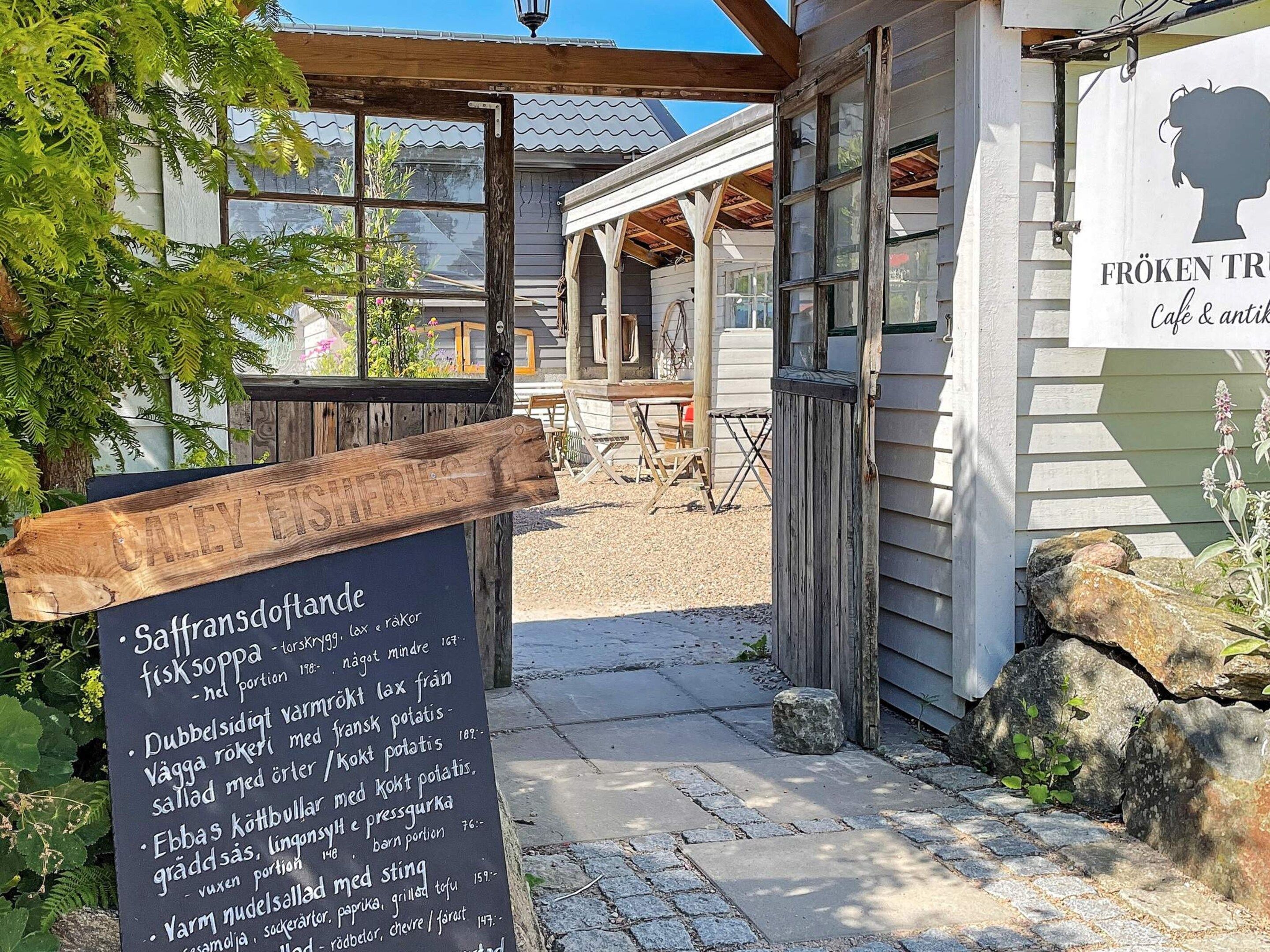 A wooden signboard with a menu listing various dishes.