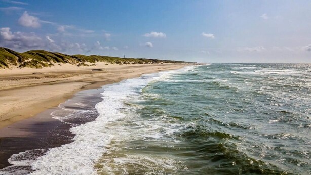 A beach with waves, a sandy shore, and dunes. - 4 Star Holiday Home in Ringkobing (Ringkobing)