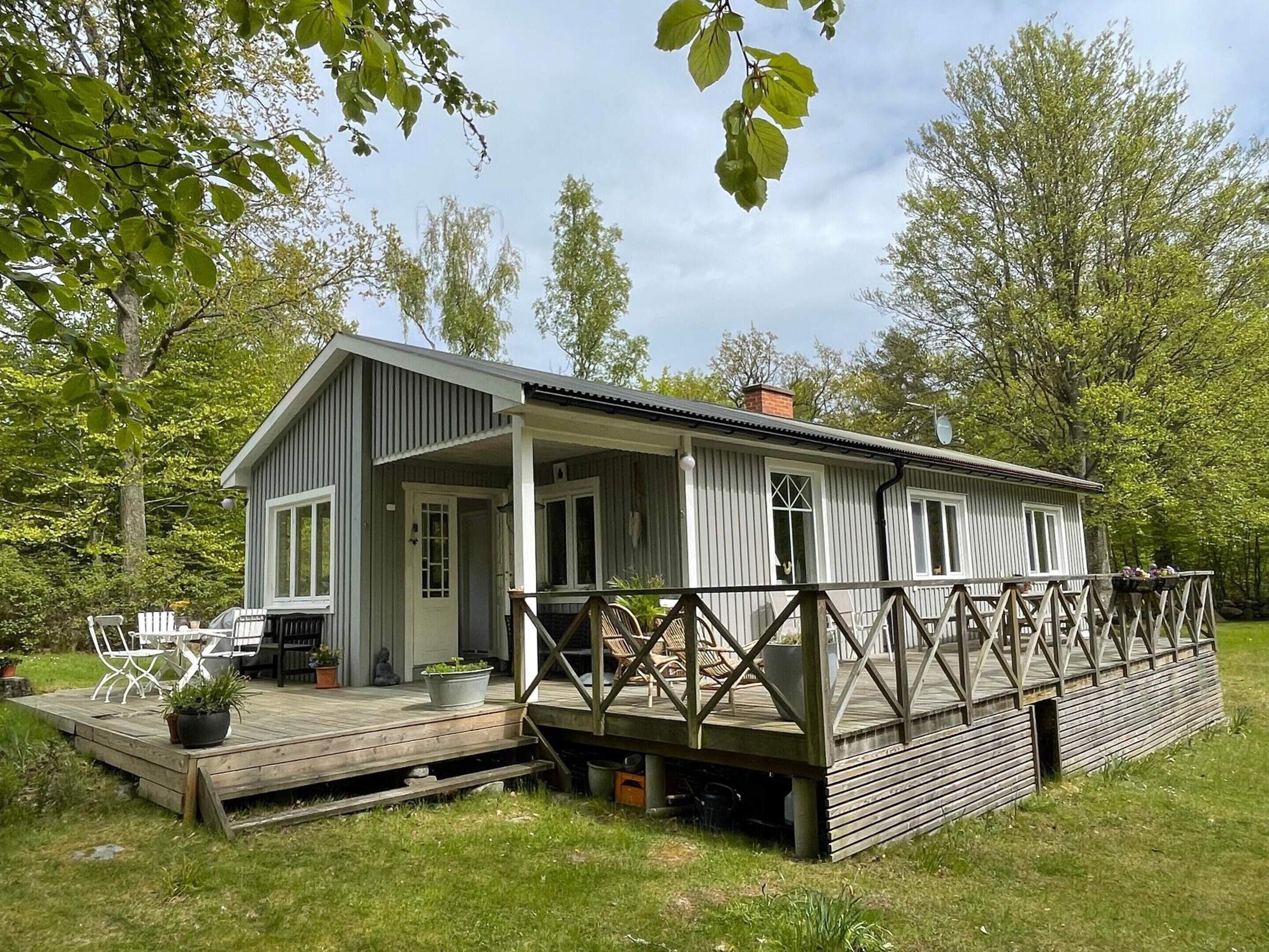 Una baita con veranda, area salotto esterna e portico coperto.