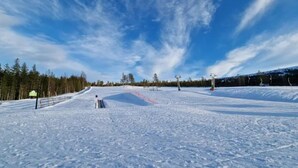 A snowy ski slope with a clear sky, ski lifts, and a forested area. - 4 Star Holiday Home in Salen (Salen)