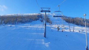 A ski lift with cables and chairs, a snowy landscape, and a clear blue sky. - 4 Star Holiday Home in Salen (Salen)