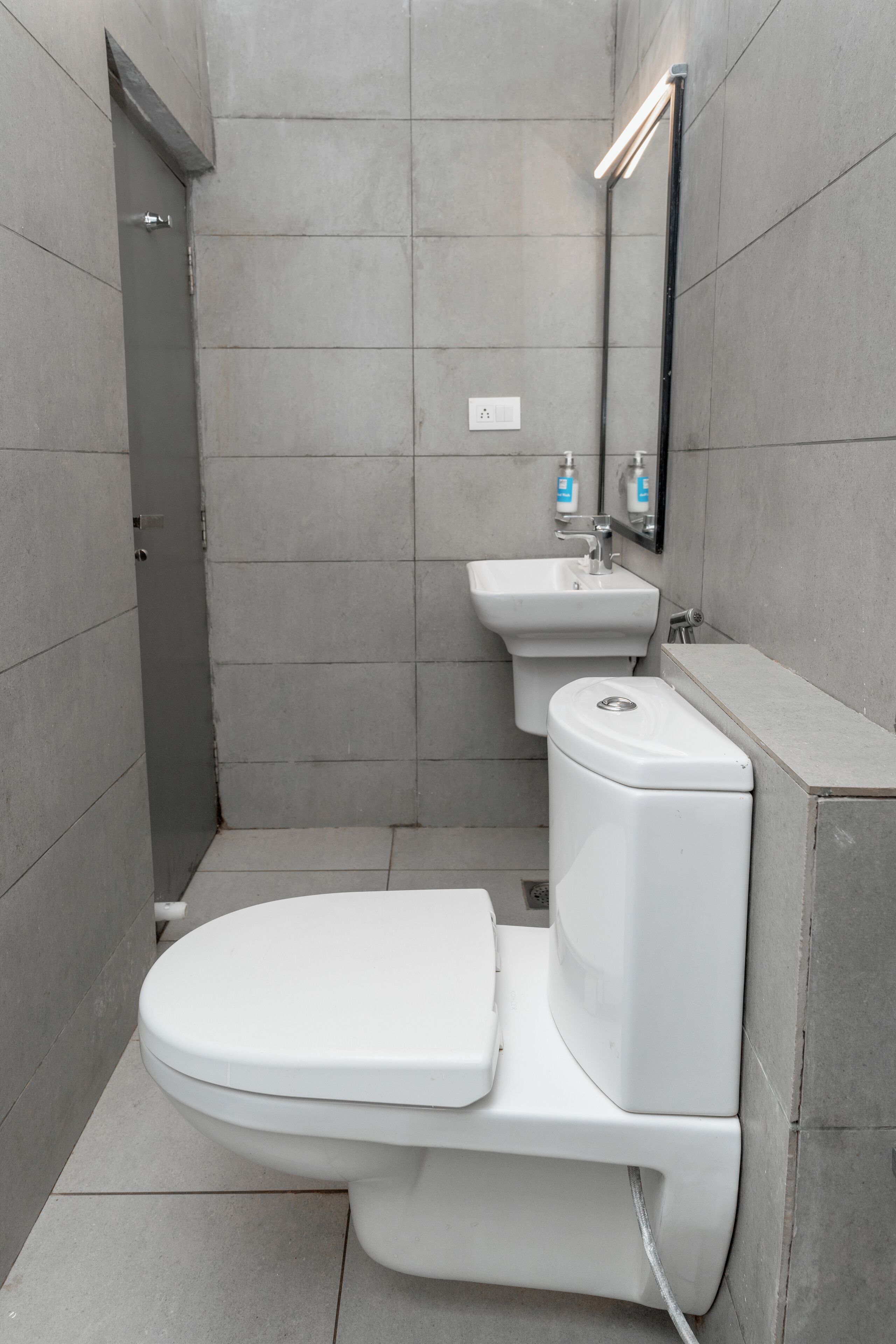 Uma casa de banho moderna com sanita, lavatório e espelho.