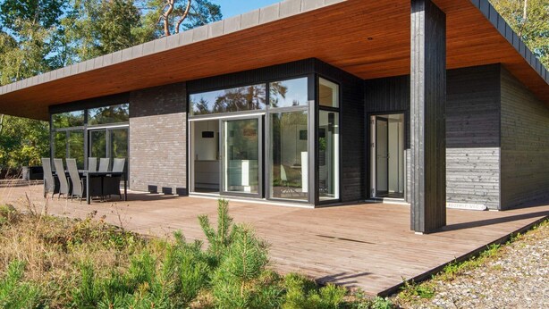 A modern house with a wooden deck, large glass windows, and a brick exterior. - 8 Person Holiday Home in Knebel (Knebel)