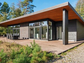 A modern house with a wooden deck, large glass windows, and a brick exterior. - 8 Person Holiday Home in Knebel (Knebel)