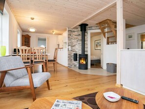 Cozy living space with a central fireplace, dining area, and kitchen.