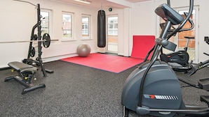 A gym with exercise equipment, a punching bag, and a red mat. - 8 Person Holiday Home in Romo (Rømø)