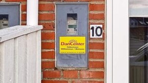 Ein Backsteinhaus mit einem DanCenter-Schild und der Nummer 10 an der Wand.