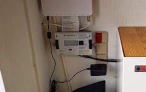 En termostat, ett eluttag och en kontrollpanel med en röd knapp.