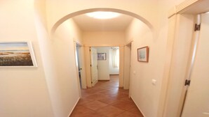 A hallway with a tiled floor, white walls, and framed pictures. - Beachfront Home in La Isleta (La Isleta)