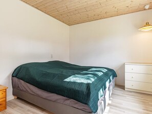 A bedroom with a bed, a dresser, and a ceiling light. - 6 Person Holiday Home in Rudkobing (Rudkobing)