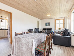 A spacious living area with a dining table, chairs, a sofa, and a fireplace.