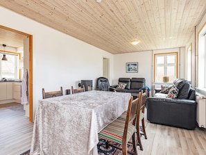 Una sala de estar acogedora con una mesa de comedor, sillas, un sofá y una chimenea.