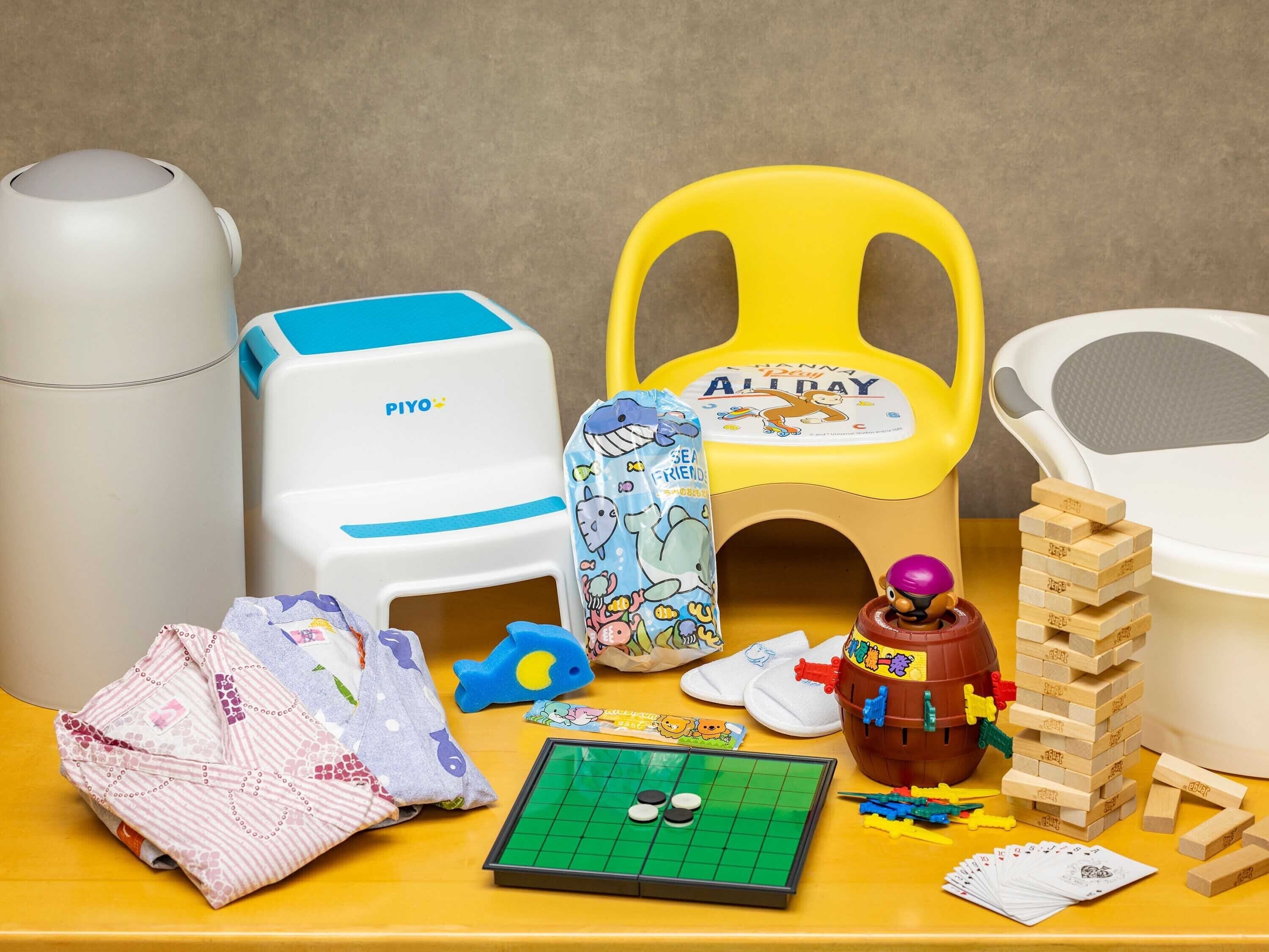 Una mesa con diversos juguetes y juegos infantiles, incluyendo un rompecabezas, un coche de juguete y una torre de Jenga.