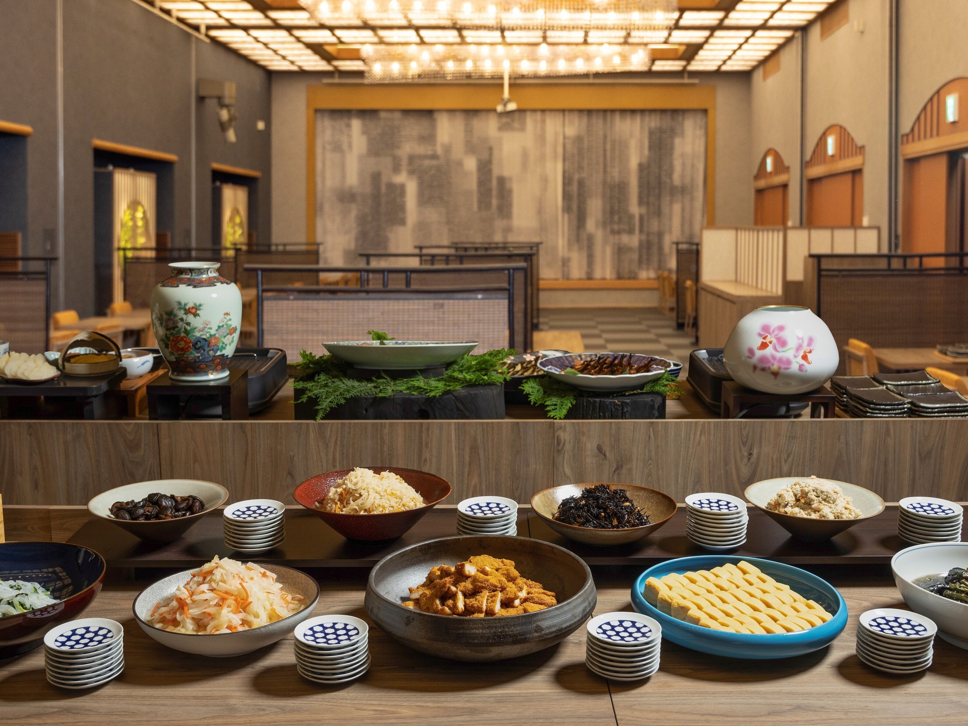 Uma sala de jantar com várias mesas dispostas, com diversos pratos, incluindo tigelas de comida e travessas.