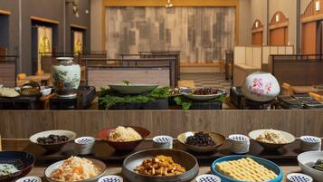 Uma sala de jantar com várias mesas dispostas, com diversos pratos, incluindo tigelas de comida e travessas.