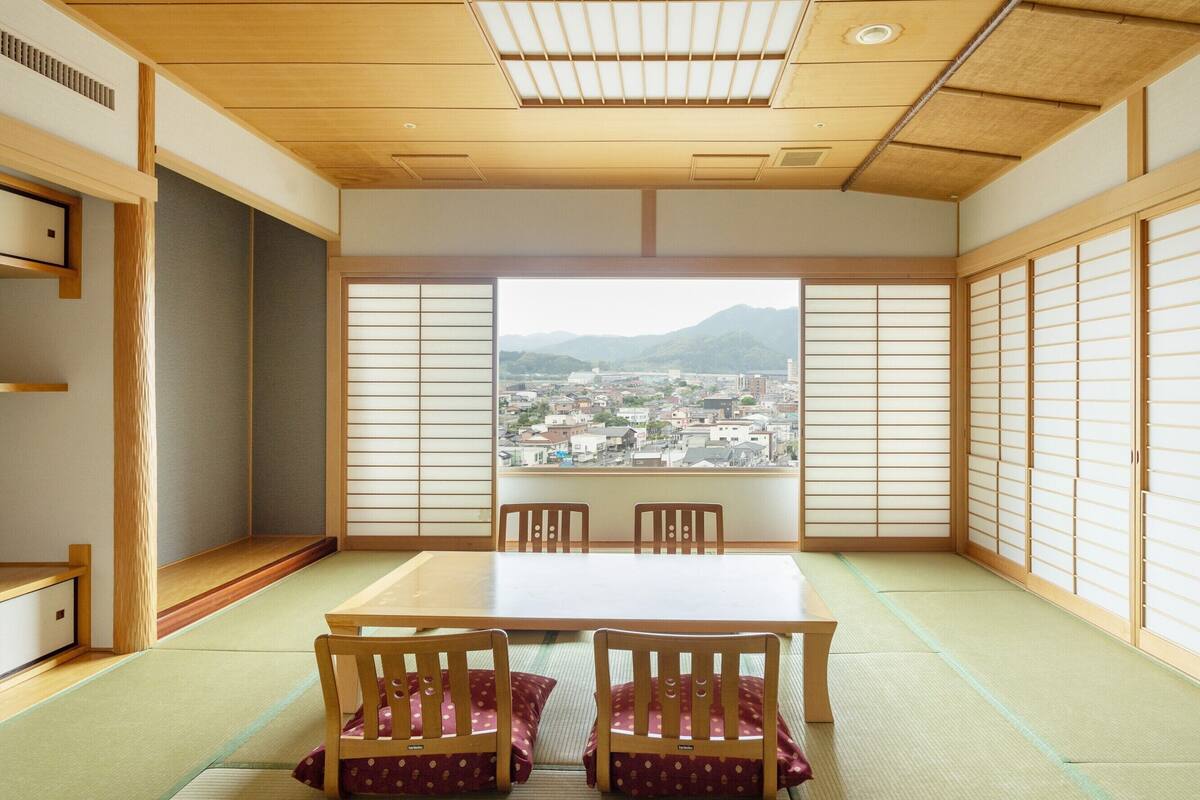 A traditional Japanese room with tatami flooring, a low table, and sliding doors.