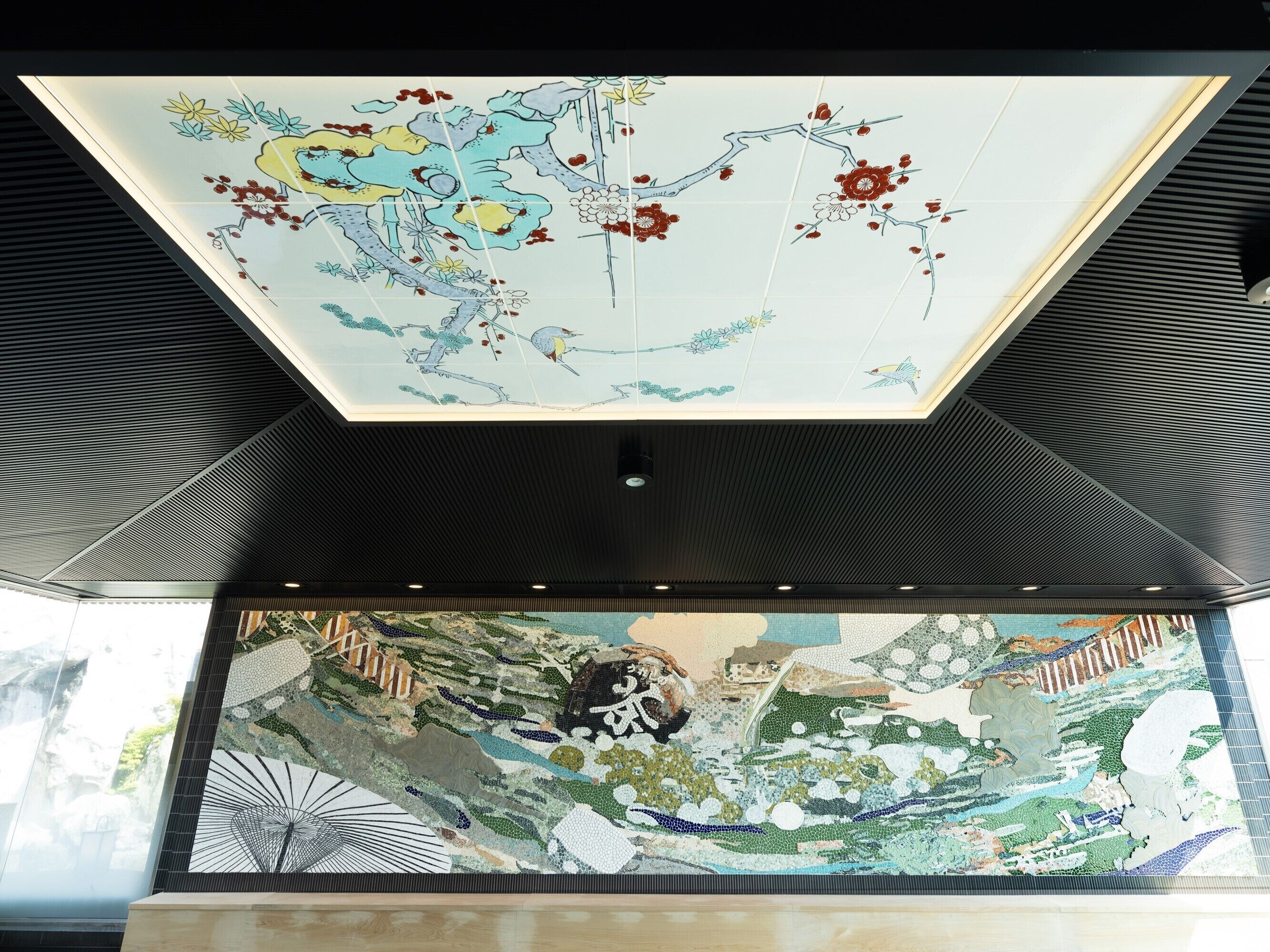 Un soffitto con una grande mappa colorata e un'opera d'arte a mosaico dettagliata sottostante.