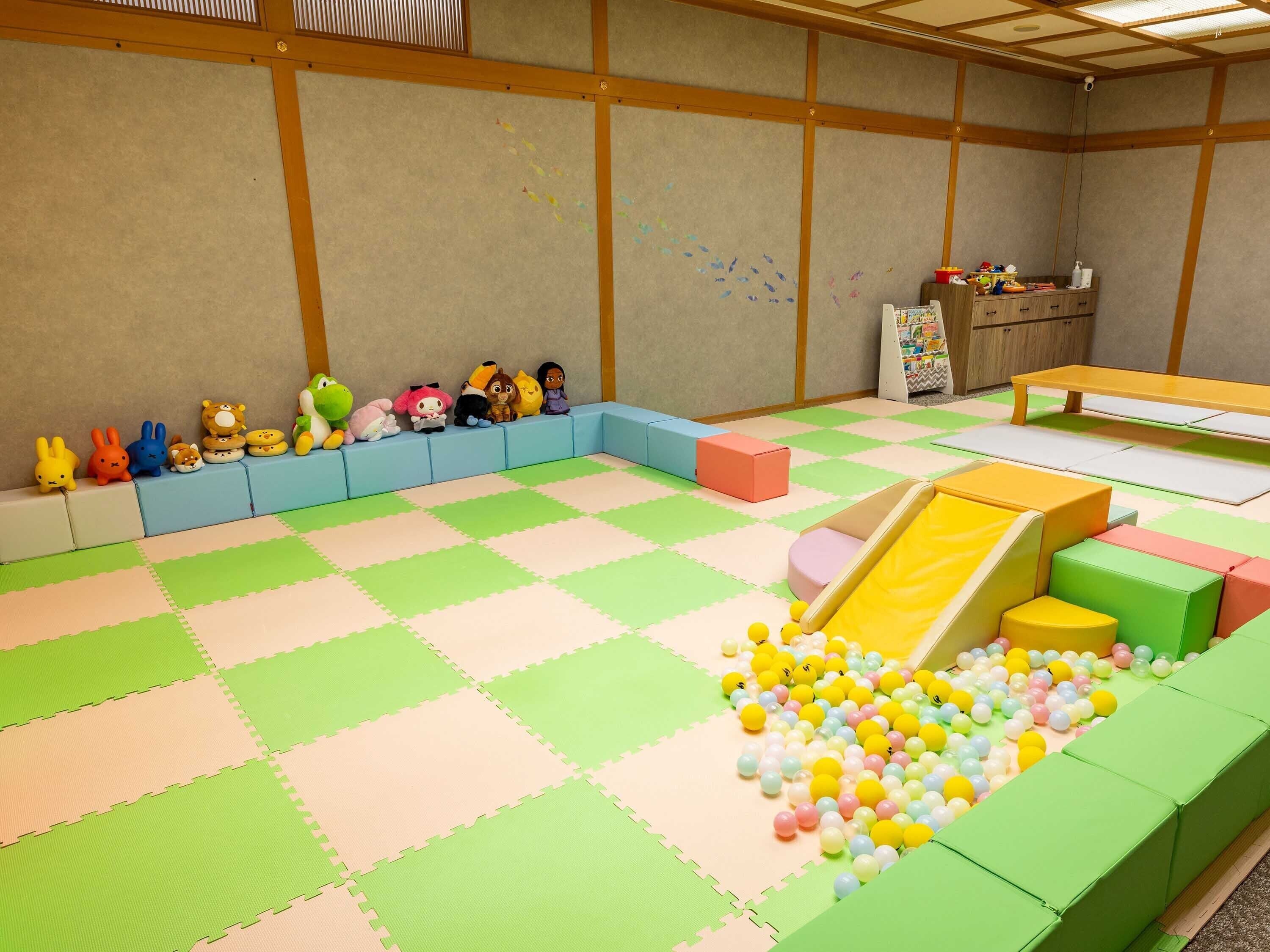 A play area with foam blocks, a ball pit, and a slide.
