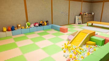 A play area with foam blocks, a ball pit, and a slide.