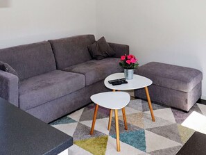 A grey sofa with a small white table and a potted plant in the center. - 4 Star Holiday Home in Varberg (Varberg)