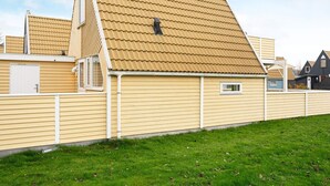 En boligbygning med skråt tag, et lille vindue og en dør.