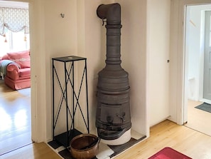 A room with a wood-burning stove, a small table, and a red rug. - 4 Person Holiday Home in Asbro (Asbro)