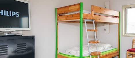 Een stapelbed met een ladder, een televisie op een kast, en een raam met uitzicht.