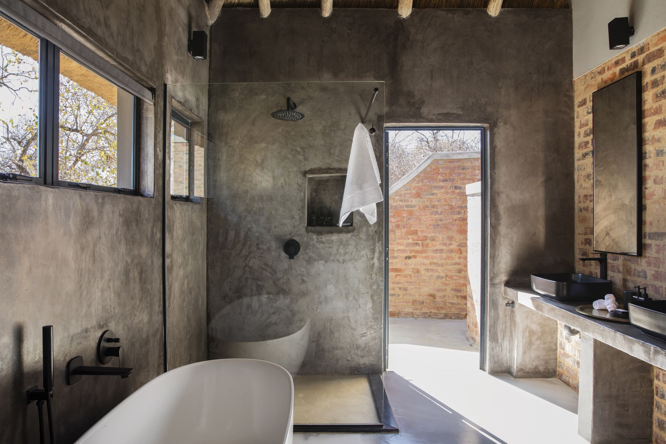 A modern bathroom with a freestanding bathtub, a shower, and a large mirror.